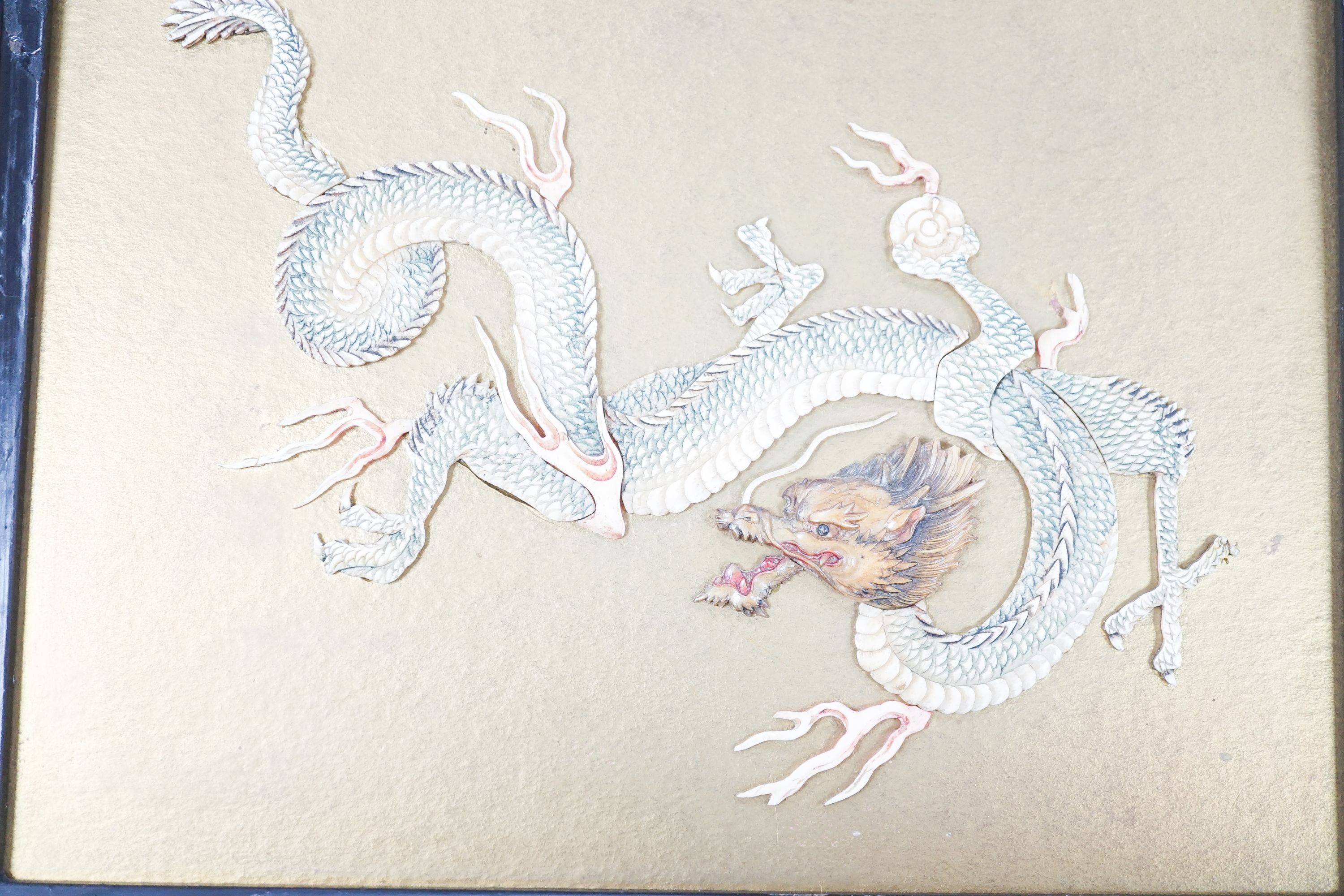 A Japanese bone ‘dragon’ and lacquer framed panel, early 20th century, 31 x 37 cm